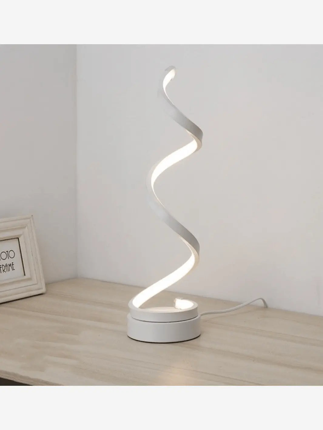 Table de chevet comportant une lampe de chevet LED originale et moderne de couleur blanche formant une spirale