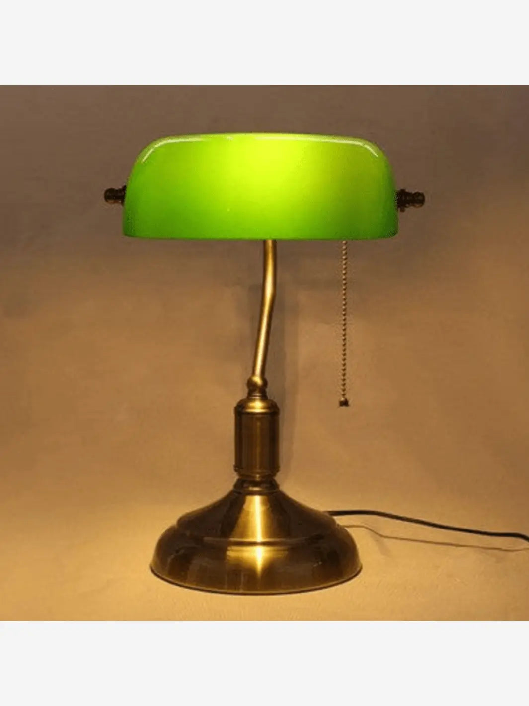 lampe de chevet type lampe de bureau vintage avec abat jour en verre vert ficelle pour allumer la lampe et pied en bronze allumee