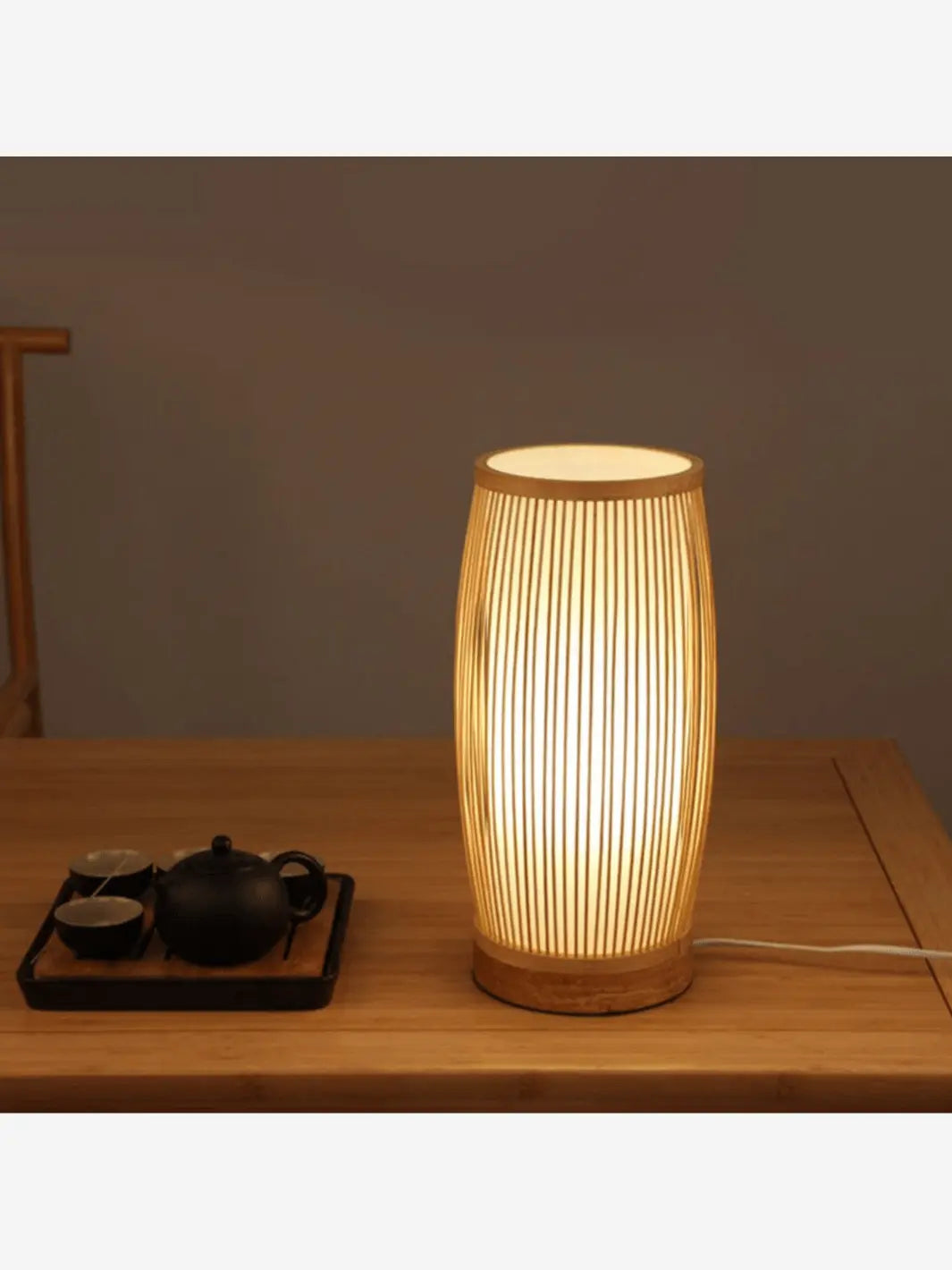 lampe de chevet bambou longue cozy posee sur une table en bois avec un service a the japonais