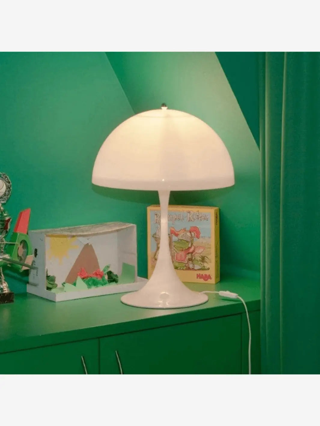 Lampe de chevet blanche champignon sur une table de chevet avec d'autres éléments décoratifs