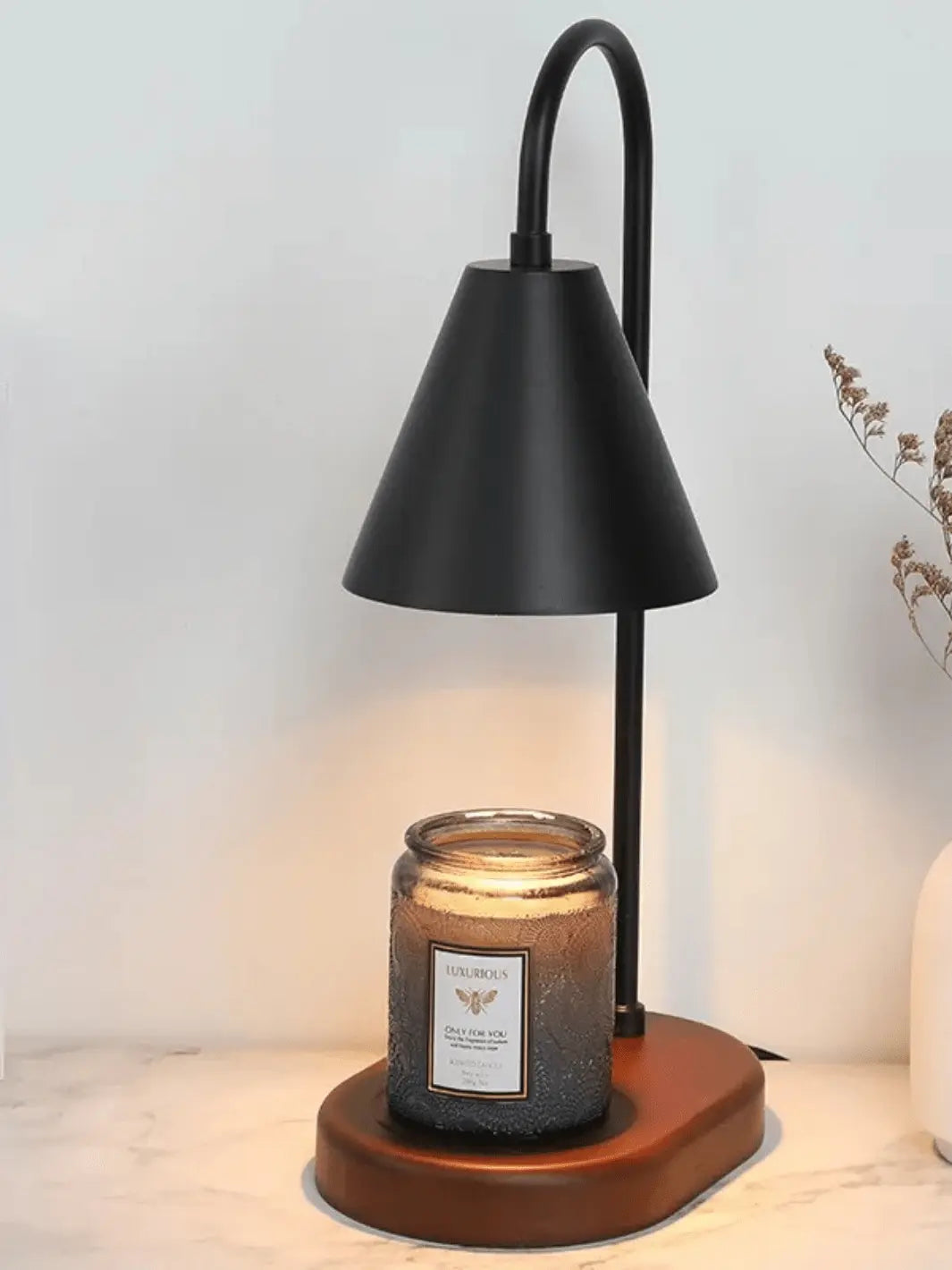 lampe de chevet chauffe bougie avec abat jour noir et socle en bois sur lequel on pose une bougie qui fond grace a la lumiere de la lampe posee sur une table de chevet en marbre