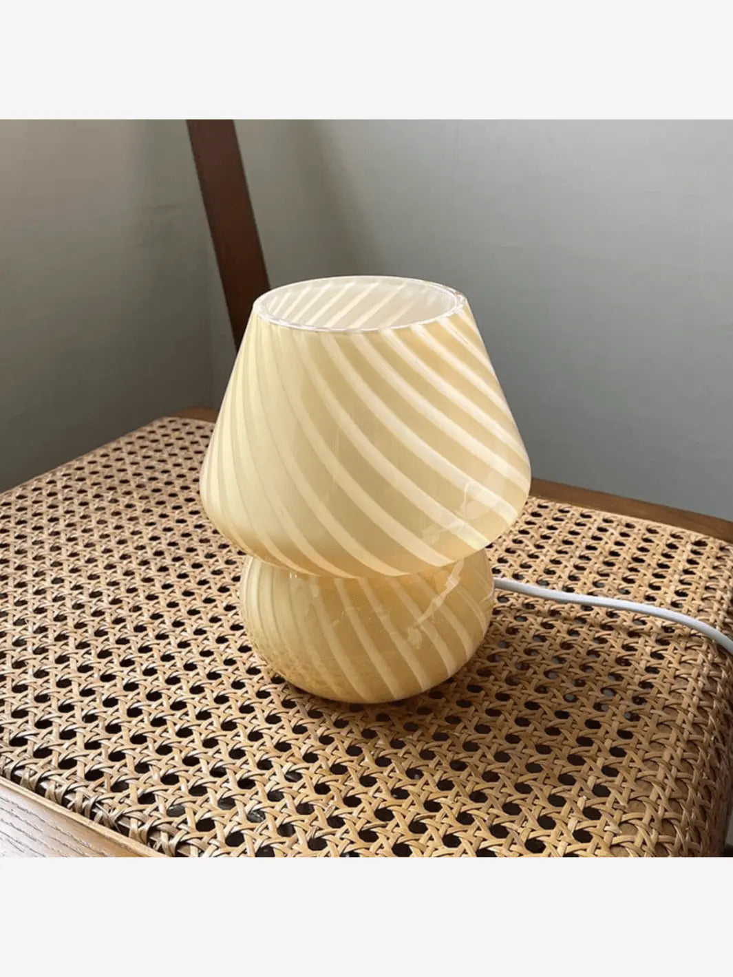 Lampe de chevet champignon beige de petite taille posée sur une chaise en bois