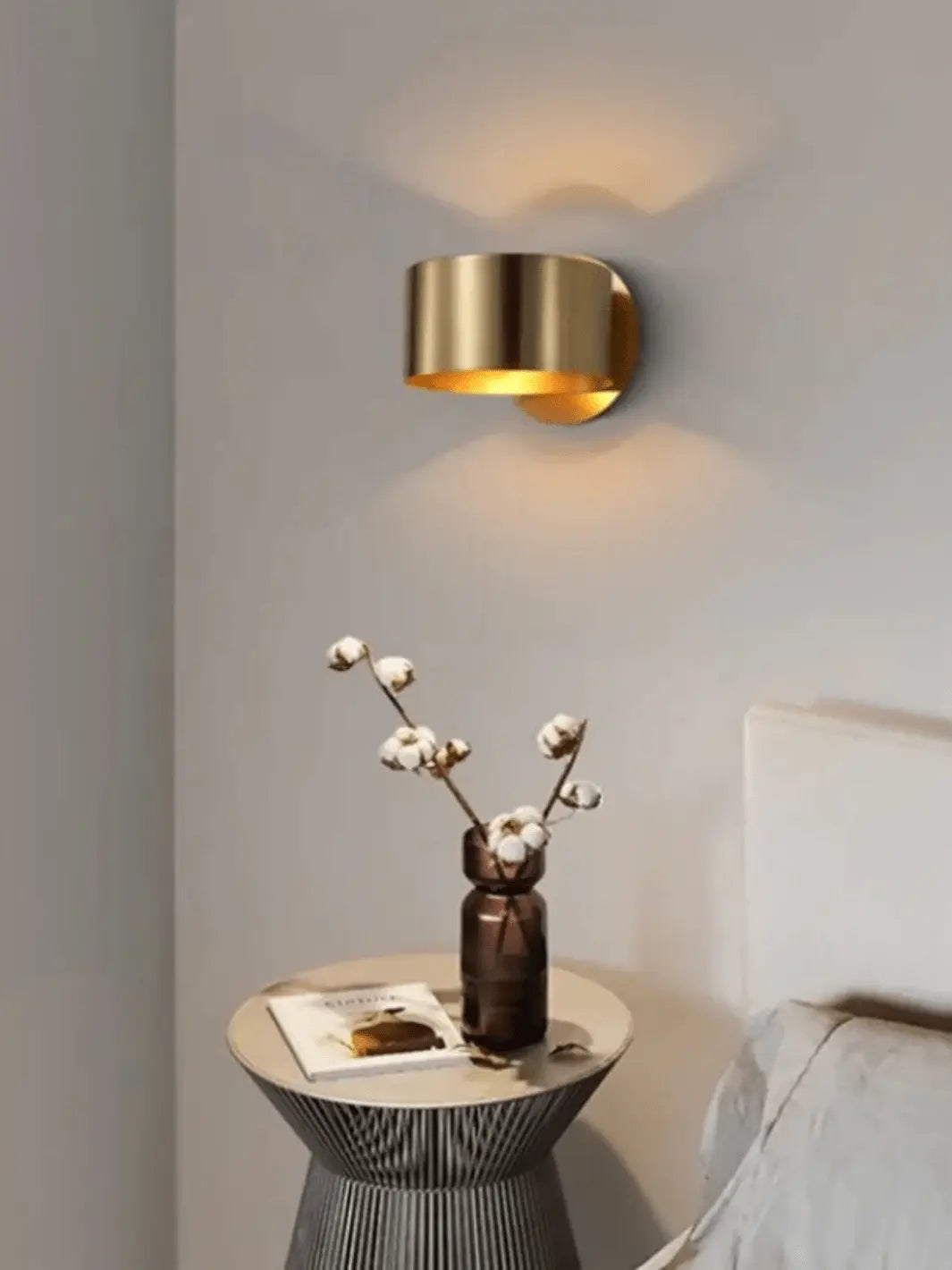 lampe de chevet murale moderne metal couleur or dans une chambre avec table de nuit design decoree d un vase 