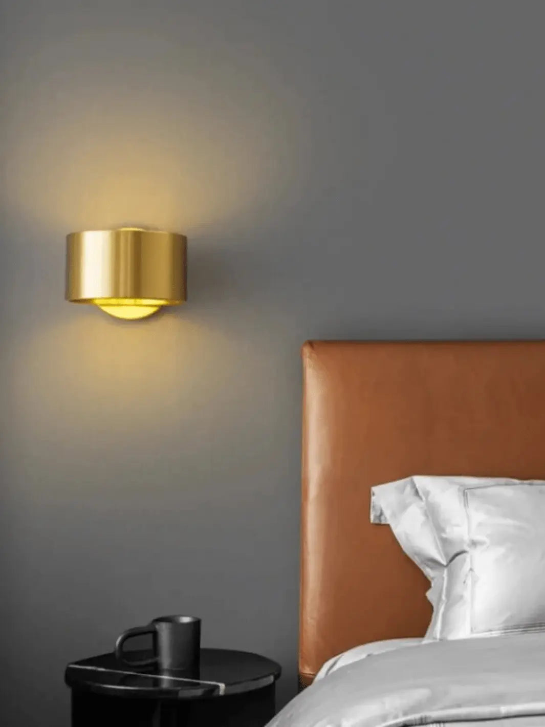 lampe de chevet murale metal couleur or moderne et design dans une chambre avec un lit et une table de nuit noire