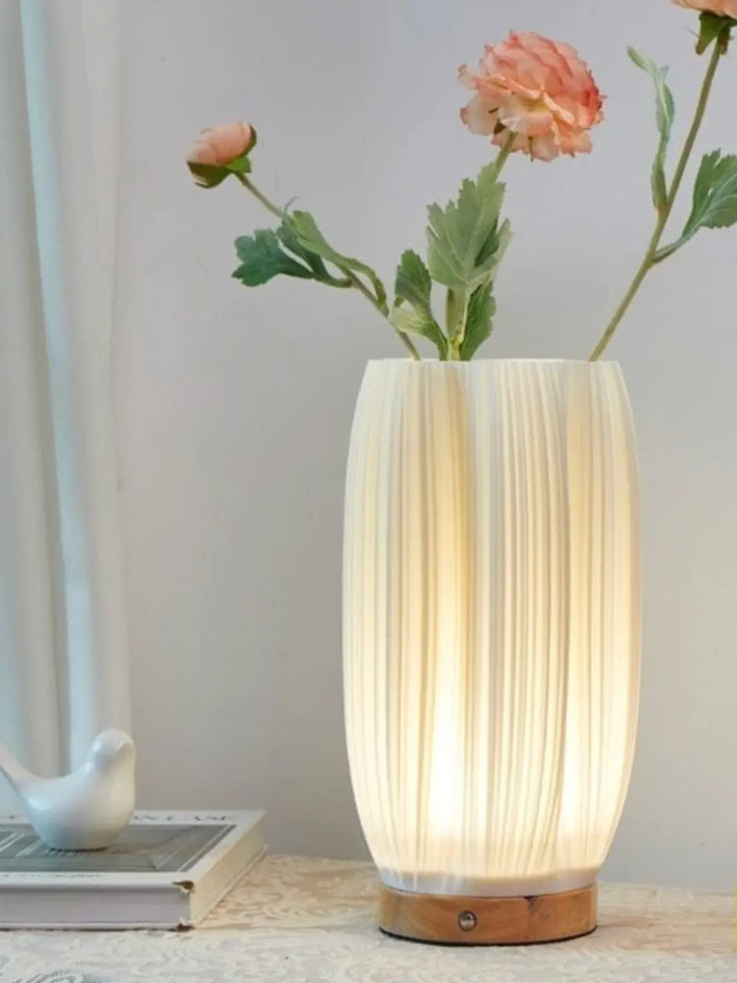 lampe de chevet faisant vase lumineux avec des fleurs roses 