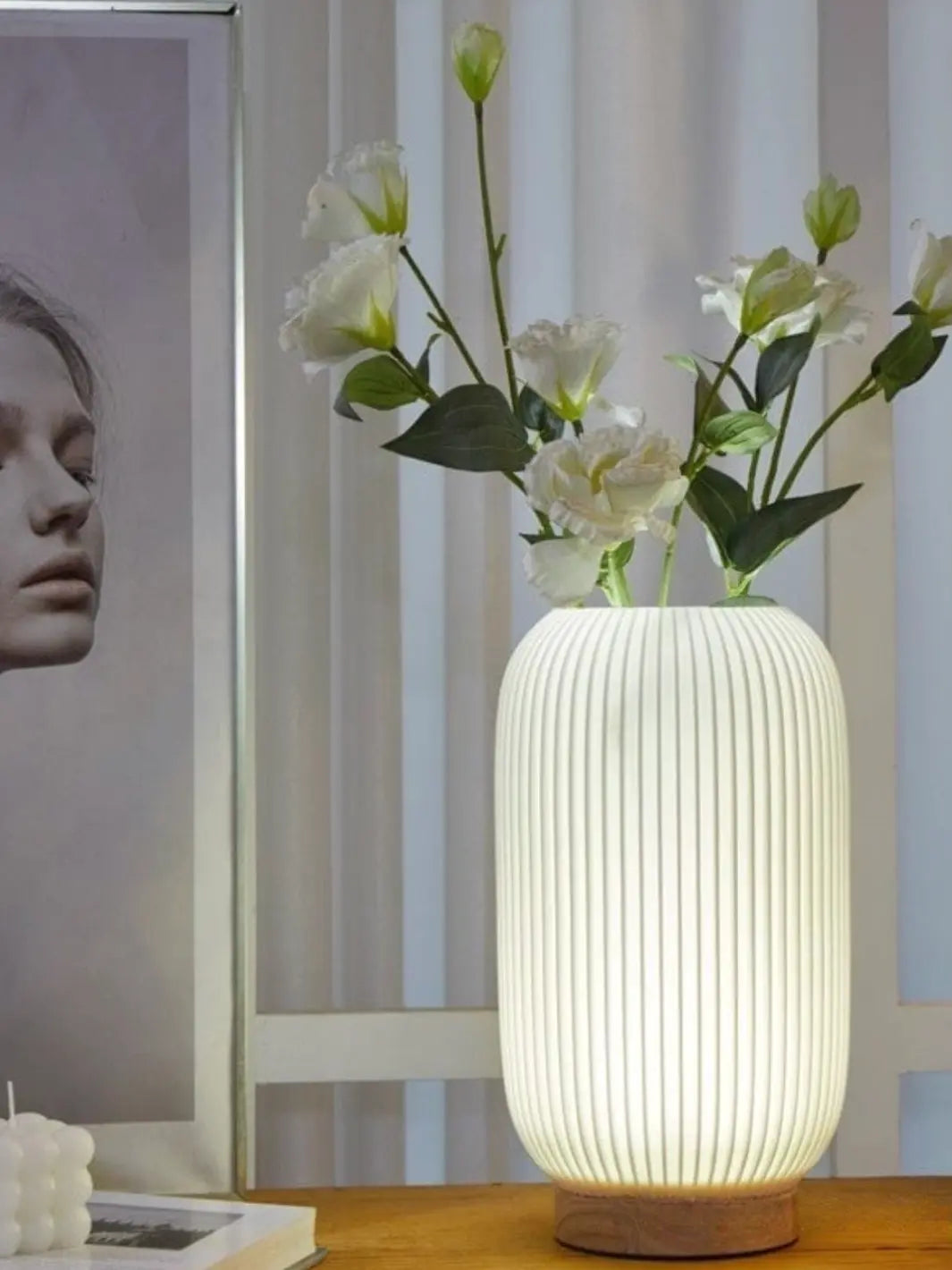 vase lumineux faisant lampe de chevet avec des roses blanches