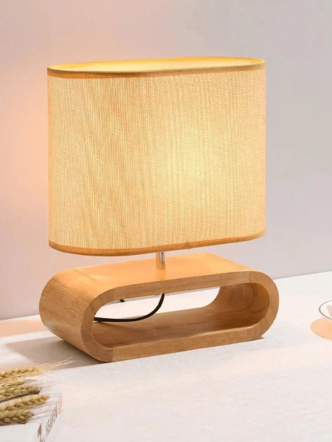 lampe de chevet scandinave avec abat jour en tissu et pied en bois clair moderne et cozy posee sur un meuble de salon blanc