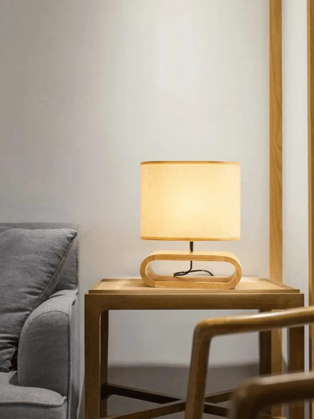 lampe de chevet scandinave avec abat jour en tissu et socle en bois clair moderne et cozy posee sur une table de chevet en bois