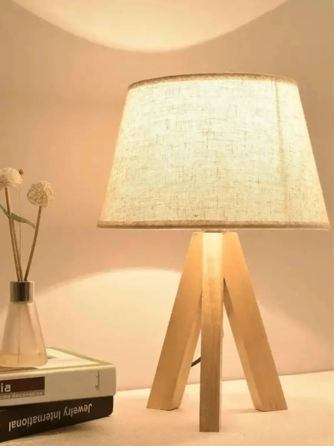 lampe de chevet sur pied en bois scandinave avec abat jour en tissu clair allumee posee dans un decor cozy
