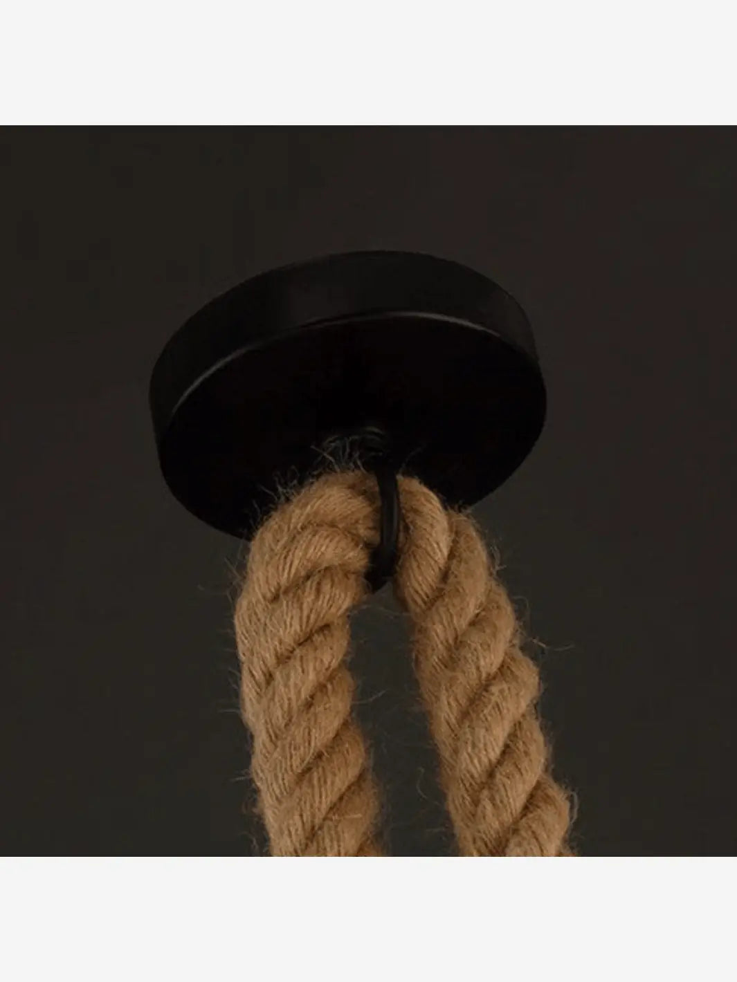 Socle noir d'une lampe de chevet suspendue en corde